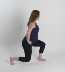 A woman demonstrates the split squat exercise. This can be an example of prolapse-safe exercise.